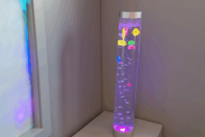 Picture of plastic fishes being moved by bubbles in a long vertical tube of bubbles